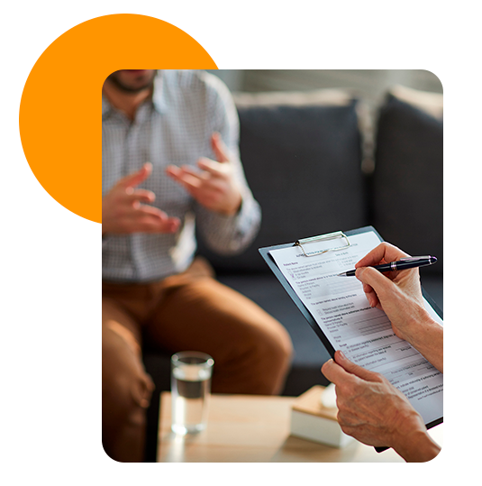 Psicóloga realizando apuntes mientras atiende a su paciente